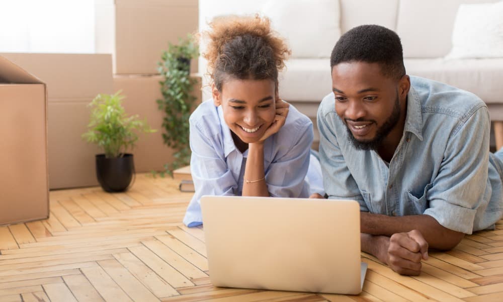 A couple looking at real estate video on a laptop in their home